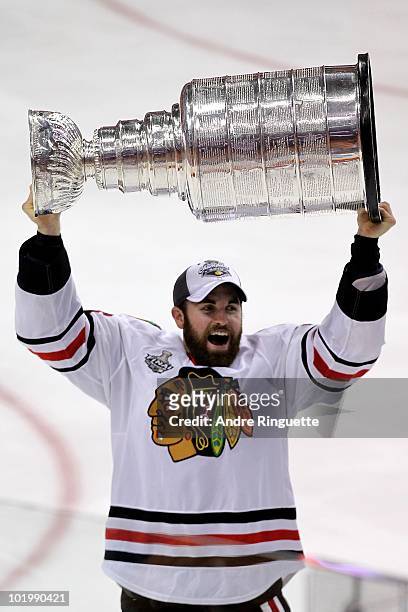 Andrew Ladd of the Chicago Blackhawks hoists the Stanley Cup after teammate Patrick Kane scored the game-winning goal in overtime to defeat the...