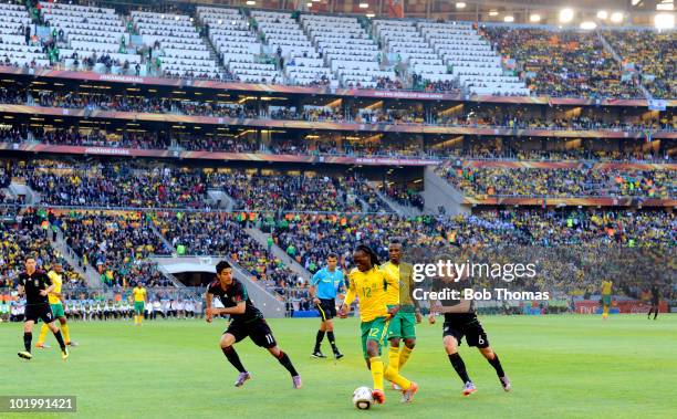 Reneilwe Letsholonyane of South Africa moves away from Gerardo Torrado of Mexico during the 2010 FIFA World Cup South Africa Group A match between...