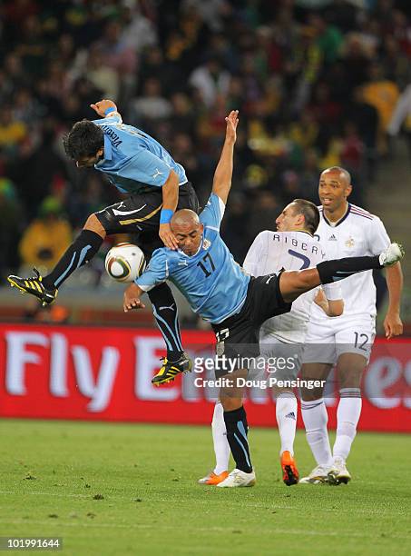 Egidio Arevalo Rios and Mauricio Victorino of Uruguay both go in for a challenge on Franck Ribery of France during the 2010 FIFA World Cup South...