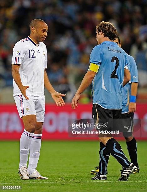 Thierry Henry of France speaks to Diego Lugano of Uruguay during the 2010 FIFA World Cup South Africa Group A match between Uruguay and France at...