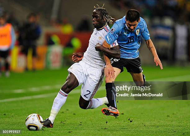 Maximiliano Pereira of Uruguay challenges Bakari Sagna of France during the 2010 FIFA World Cup South Africa Group A match between Uruguay and France...
