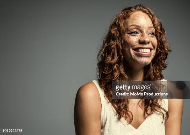 studio portrait of laughing woman with freckles - looking away stockfoto's en -beelden