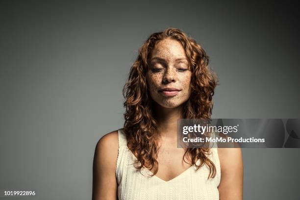 studio portrait of woman with freckles - geschlossene augen stock-fotos und bilder