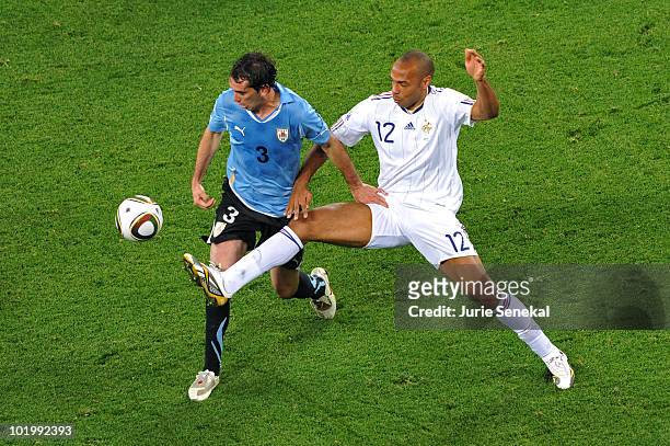 Diego Godin of Uruguay and Thierry Henry of France battle for the ball during the 2010 FIFA World Cup South Africa Group A match between Uruguay and...