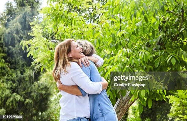 women embracing - mature women talking stock pictures, royalty-free photos & images
