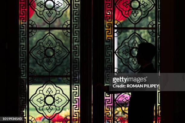 Doorman waits to open the door at Diaoyutai State Guesthouse during the meeting of Malaysian Prime Minister Mahathir Mohamad and Chinese President Xi...