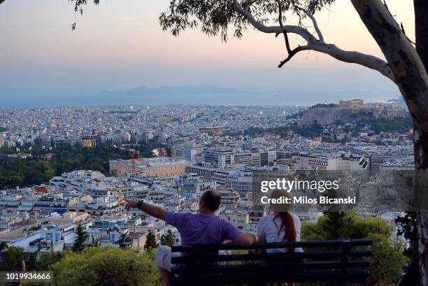 Couple sit on Lycabettus Hill on August 18 2018 in Athens, Greece. Greece's final bailout officially ends after eight years of hugely unpopular and...