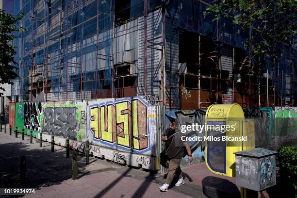 People walk past a derelict building on August 20, 2018 in Athens, Greece. Greece's final bailout officially ends after eight years of hugely...