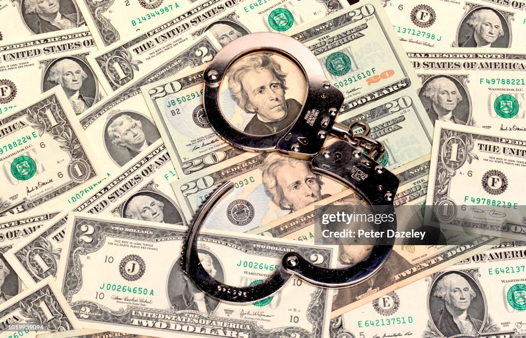 Handcuffs sitting on top of US paper currency