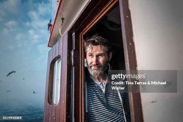 bearded fisherman on his ship. - bootskapitän stock-fotos und bilder