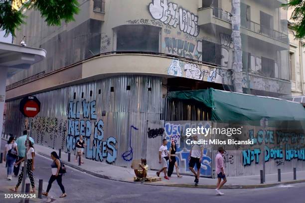 People walk past a derelict building on August 18, 2018 in Athens, Greece. Greece's final bailout officially ends after eight years of hugely...