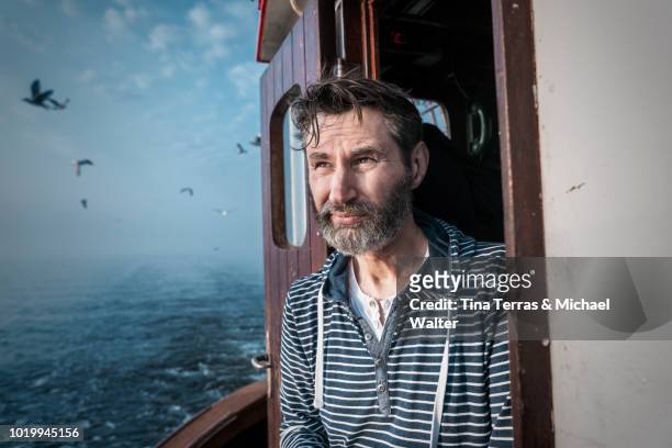 bearded fisherman on his ship. - fisherman foto e immagini stock