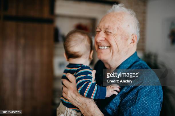 great grandfather filled with joy embracing his great grandson - grandfather stock pictures, royalty-free photos & images