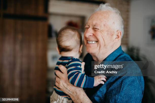 great grandfather filled with joy embracing his great grandson - baby grandpa imagens e fotografias de stock