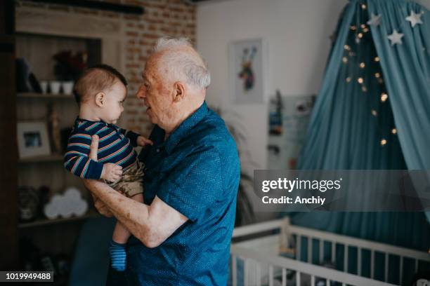 grandfather embracing his baby grandson - active baby boomer stock pictures, royalty-free photos & images