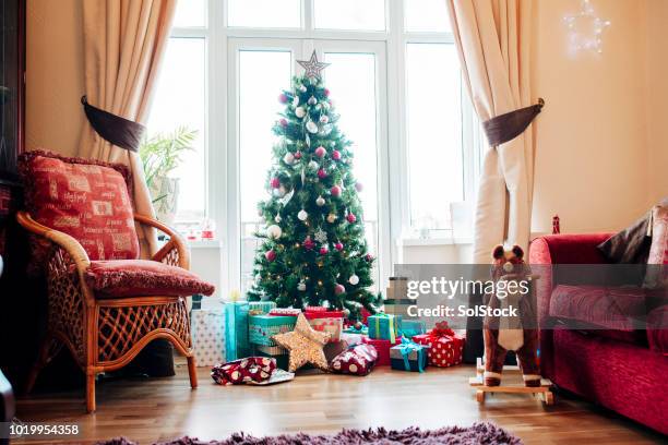 presents under the christmas tree - christmas tree living room stock pictures, royalty-free photos & images