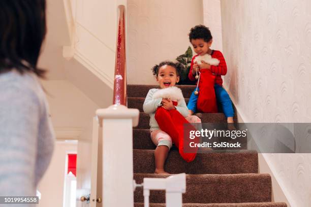 children coming down the stairs on christmas morning - step sibling stock pictures, royalty-free photos & images