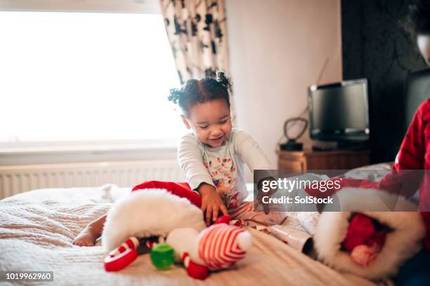 petite fille ouvrir son bas de noël le matin de noël - cute stockings photos et images de collection