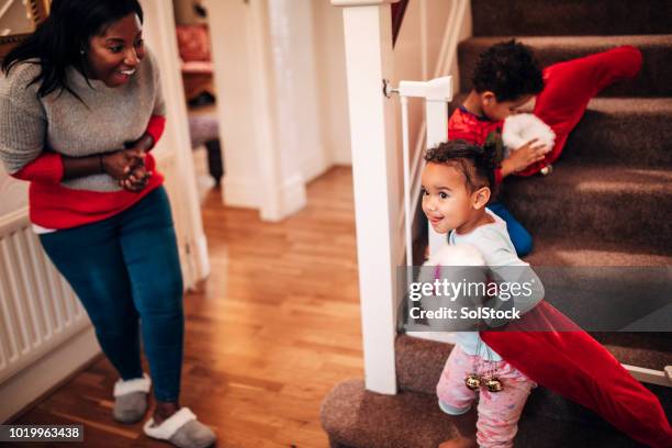 broers en zussen naar beneden de trap op kerstochtend - black women in stockings stockfoto's en -beelden