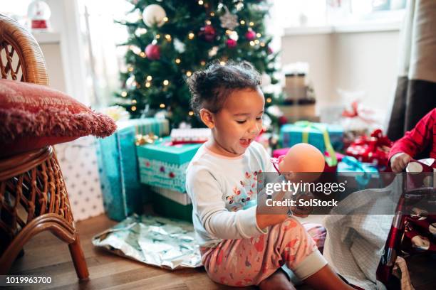bambina che apre regali la mattina di natale - giocattoli foto e immagini stock