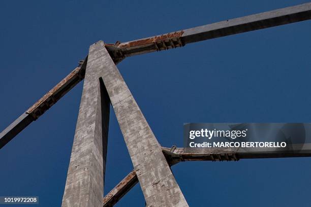 An underneath view of the Morandi motorway bridge, taken on August 16, 2018 two days after a section of the bridge collapsed, shows a detail of the...