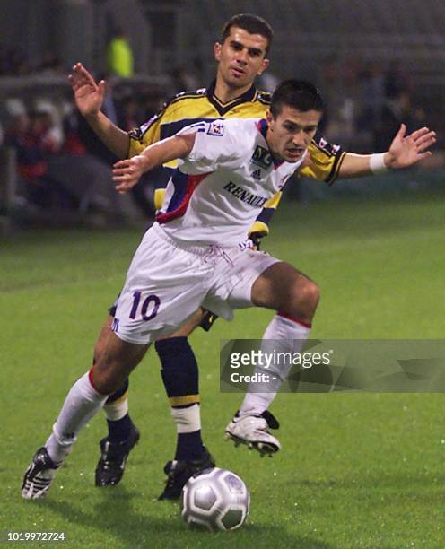 Le joueur lyonnais Eric Carrière déborde le défenseur sochalien Erwan Manach, le 20 octobre 2001 au stade de Gerland à Lyon, lors du match...
