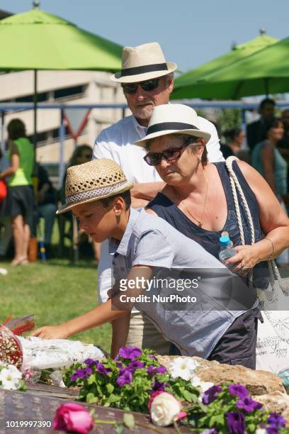 Relatives lay flowers to pay a tribute to the victims in front a commemorative monument during a ceremony to mark the 10th anniversary of the Spanair...