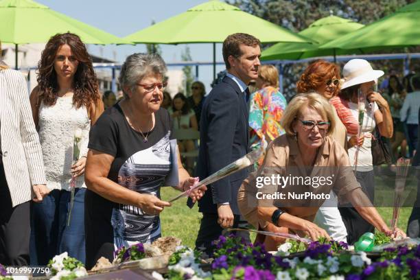 Relatives lay flowers to pay a tribute to the victims in front a commemorative monument during a ceremony to mark the 10th anniversary of the Spanair...