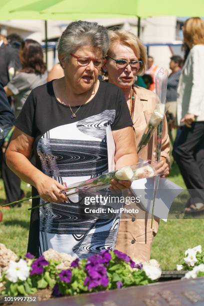 Relatives lay flowers to pay a tribute to the victims in front a commemorative monument during a ceremony to mark the 10th anniversary of the Spanair...