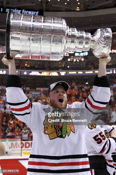 Bryan Bickell of the Chicago Blackhawks hoists the Stanley Cup after teammate Patrick Kane scored the game-winning goal in overtime to defeat the...