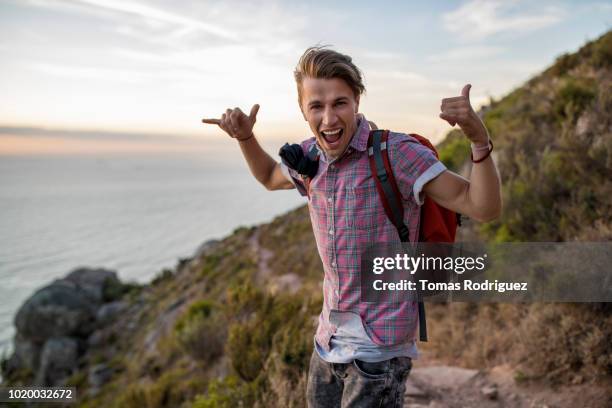 portrait of excited young man on a hiking trip at sunset - ecstatic foto e immagini stock