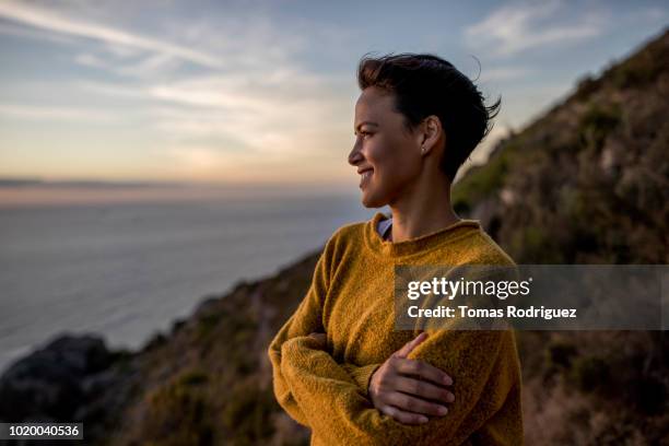 smiling woman taking a break on a hiking trip looking at view at sunset - adventure sunset stock pictures, royalty-free photos & images