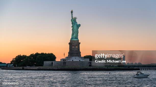 statue of liberty at sunset - new york - new york freiheitsstatue stock-fotos und bilder