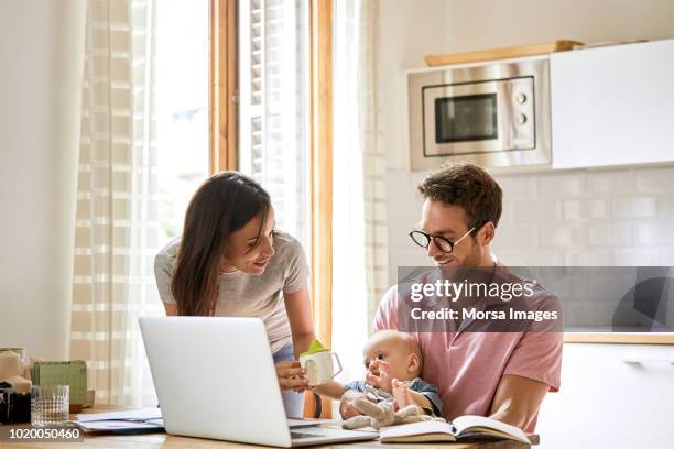 parents with son at table in domestic kitchen - family financial planning stock pictures, royalty-free photos & images