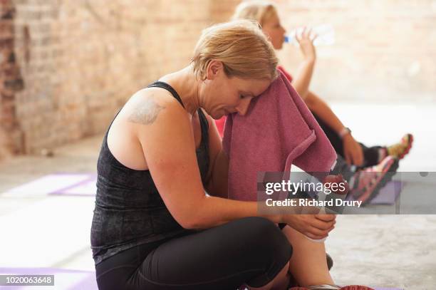 woman wiping her forehead with a towel in the gym - tired workout stock pictures, royalty-free photos & images