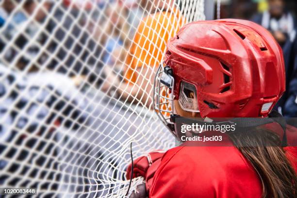 young girl ice hockey player in red equipment - girls ice hockey stock pictures, royalty-free photos & images