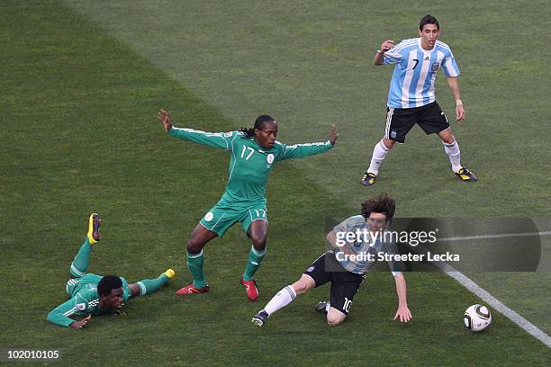 Lionel Messi of Argentina falls under the challenge of Chidi Odiah of Nigeria during the 2010 FIFA World Cup South Africa Group B match between...