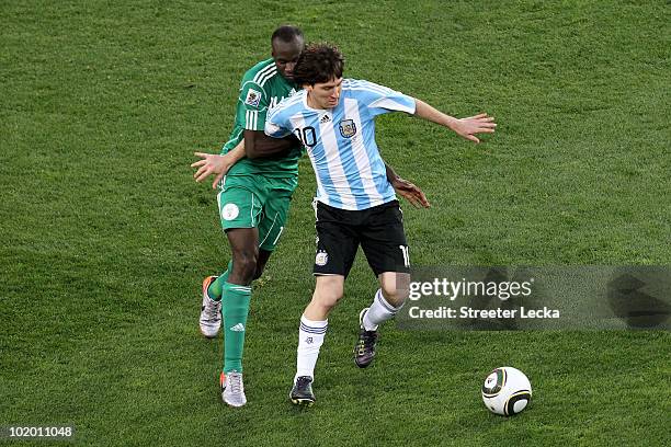 Lionel Messi of Argentina is held back by Sani Kaita of Nigeria during the 2010 FIFA World Cup South Africa Group B match between Argentina and...