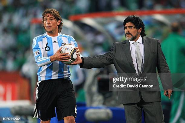 Diego Maradona head coach of Argentina hands the ball to Gabriel Heinze of Argentina during the 2010 FIFA World Cup South Africa Group B match...