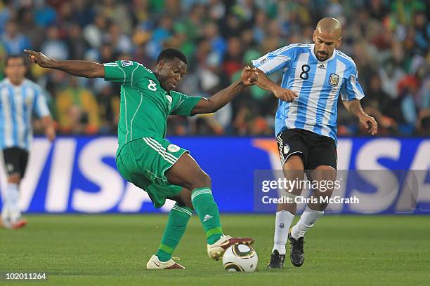 Juan Veron of Argentina challenges Yakubu Ayegbeni of Nigeria during the 2010 FIFA World Cup South Africa Group B match between Argentina and Nigeria...