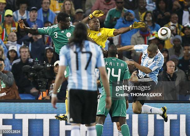 Nigeria's goalkeeper Vincent Enyeama tries to get the ball away from the ball as Nigeria's defender Taye Taiwo and Nigeria's midfielder Sani Kaita...