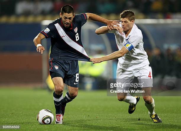 Clint Dempsey of the United States holds off a challenge by Steven Gerrard of England during the 2010 FIFA World Cup South Africa Group C match...