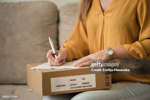 close up of a woman receiving her package - package arrival stock pictures, royalty-free photos & images