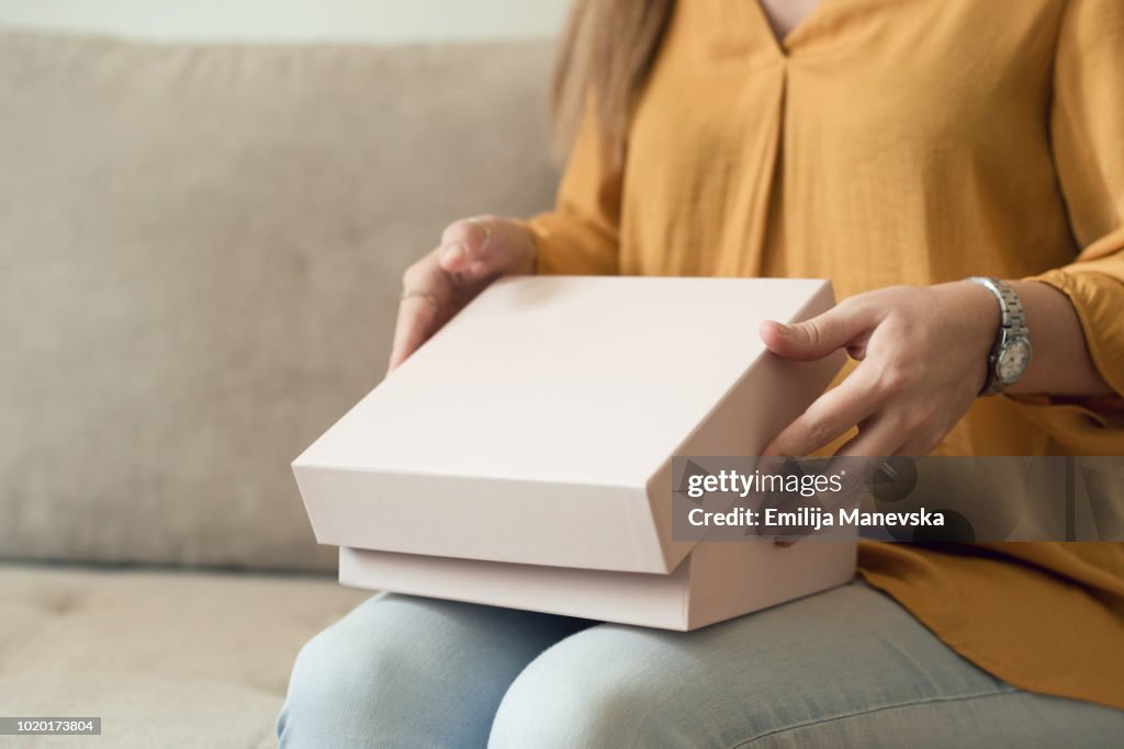 Young woman opening a package