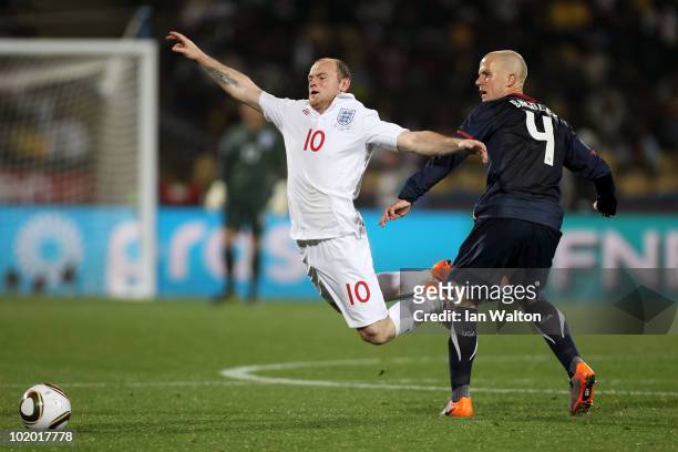 Wayne Rooney of England falls to the ground after a challenge by Michael Bradley of the United States during the 2010 FIFA World Cup South Africa...