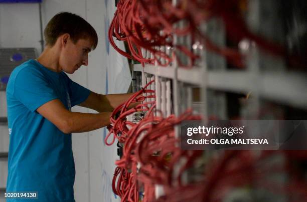 An employee inspects machines for the production of bitcoins and lightcoins at the "Kriptounivers" mining centre during a presentation of the largest...