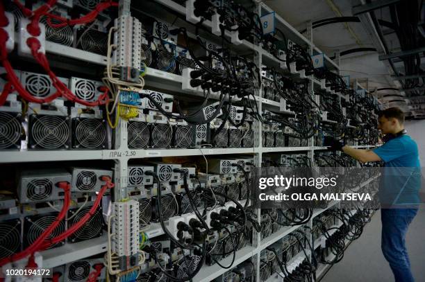 An employee inspects machines for the production of bitcoins and lightcoins at the "Kriptounivers" mining centre during a presentation of the largest...