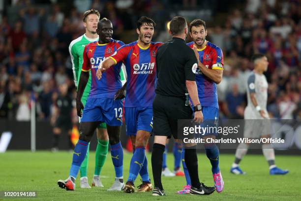Palace players James Tomkins , Mamadou Sakho and Luka Milivojevic argue with referee Michael Oliver after he awarded a penalty during the Premier...