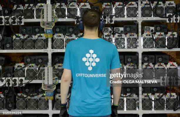 An employee inspects machines for the production of bitcoins and lightcoins at the "Kriptounivers" mining centre during a presentation of the largest...