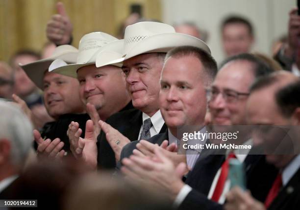Members of the Bailey County, Texas Sheriff's office applaud as U.S. President Donald Trump speaks at a "Salute to the Heroes of the Immigration and...